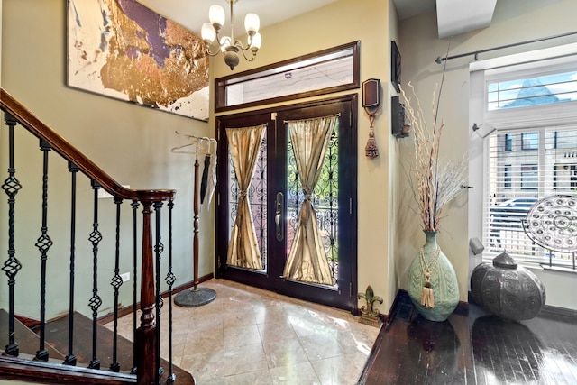 foyer entrance featuring french doors and a chandelier