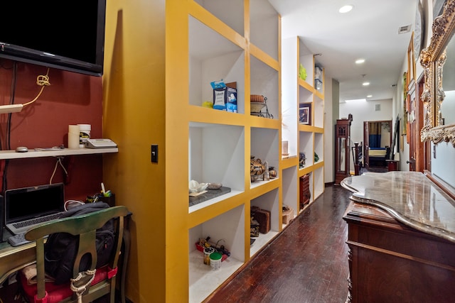 hallway featuring built in shelves and dark hardwood / wood-style flooring