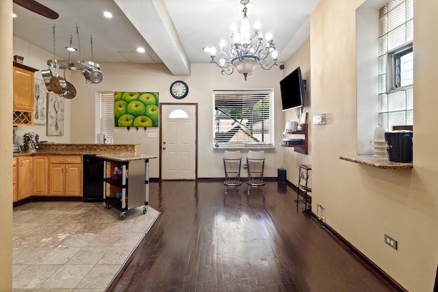 kitchen with decorative light fixtures, light stone countertops, light hardwood / wood-style flooring, and a chandelier