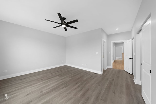 empty room with dark hardwood / wood-style floors and ceiling fan