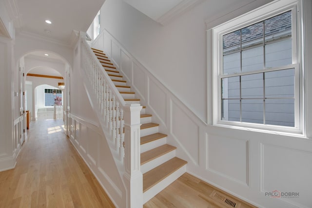 stairway with crown molding and hardwood / wood-style flooring