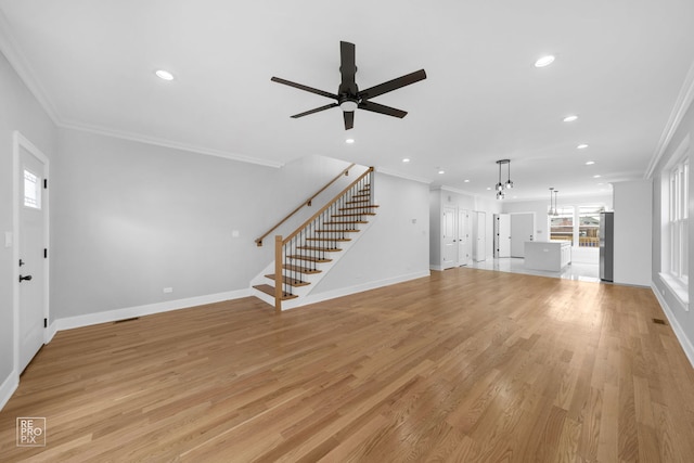 unfurnished living room featuring ceiling fan, ornamental molding, and light wood-type flooring