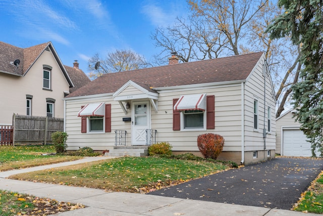 bungalow-style house featuring an outbuilding, a front yard, and a garage