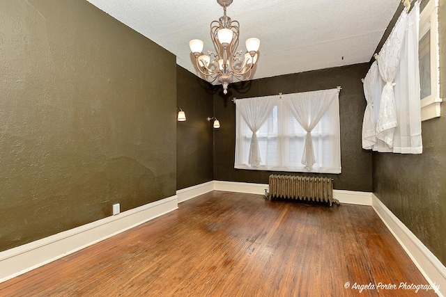 unfurnished room with radiator, a chandelier, wood-type flooring, and a textured ceiling