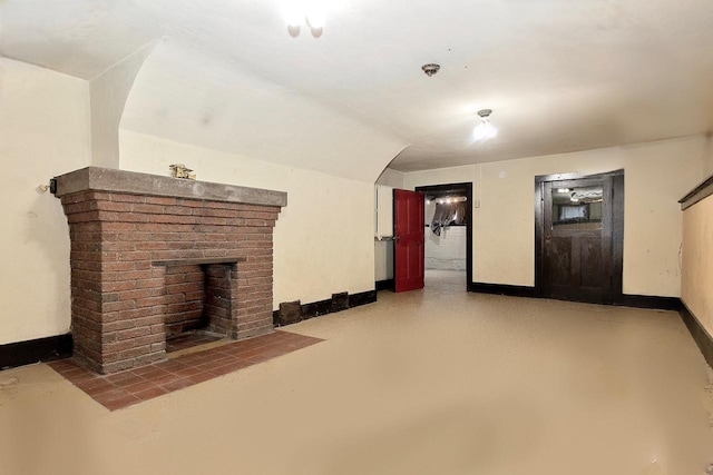 unfurnished living room with a fireplace and concrete floors