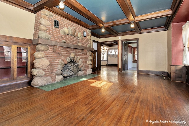 unfurnished living room featuring beamed ceiling, wood-type flooring, coffered ceiling, and a brick fireplace