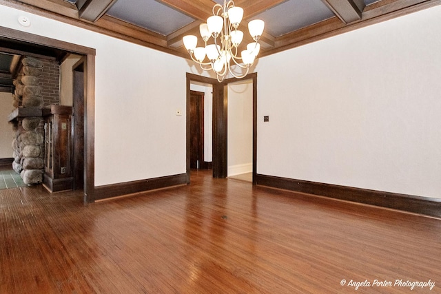 unfurnished room with coffered ceiling, beamed ceiling, a chandelier, and dark hardwood / wood-style floors