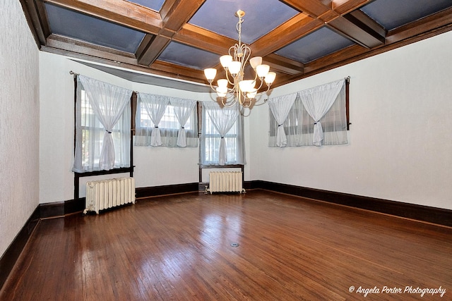 unfurnished room featuring radiator heating unit, beam ceiling, dark wood-type flooring, and coffered ceiling