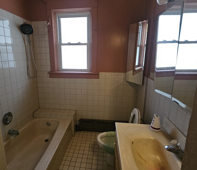 bathroom featuring vanity, tile patterned flooring, toilet, a tub to relax in, and tile walls