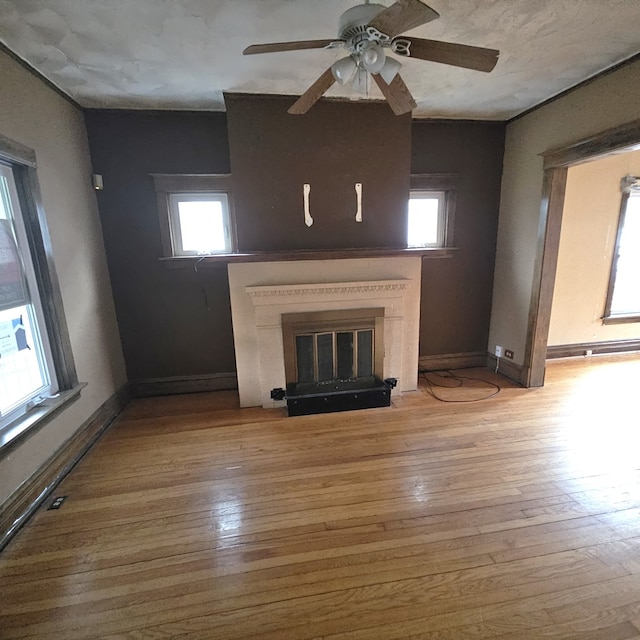 unfurnished living room with ceiling fan and light hardwood / wood-style floors