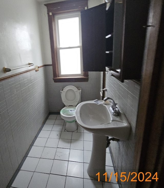 bathroom featuring tile patterned flooring, sink, toilet, and tile walls