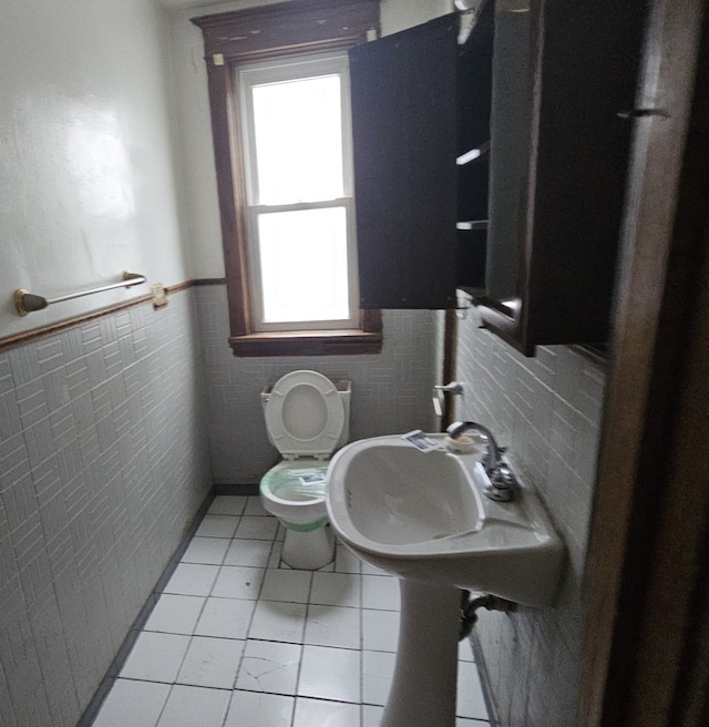 bathroom with tile patterned floors, sink, tile walls, and toilet