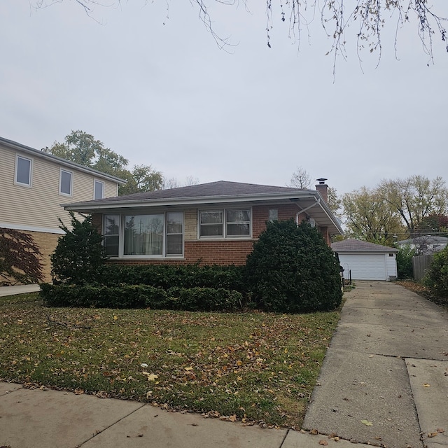 view of front facade with a garage, an outbuilding, and a front lawn