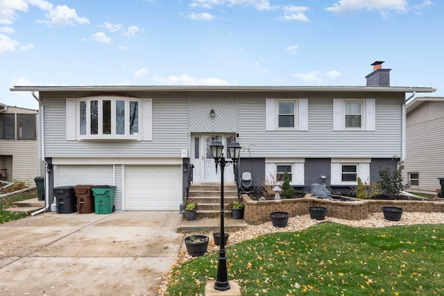 split foyer home featuring a garage and a front lawn