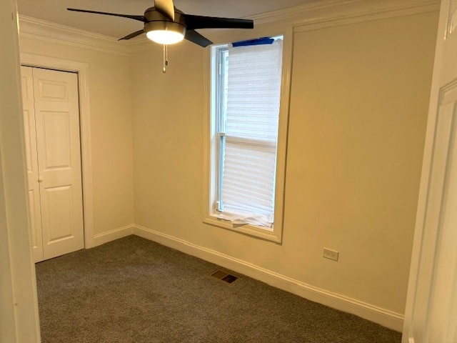 carpeted empty room with ceiling fan and ornamental molding