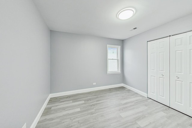 unfurnished bedroom with light hardwood / wood-style floors and a closet