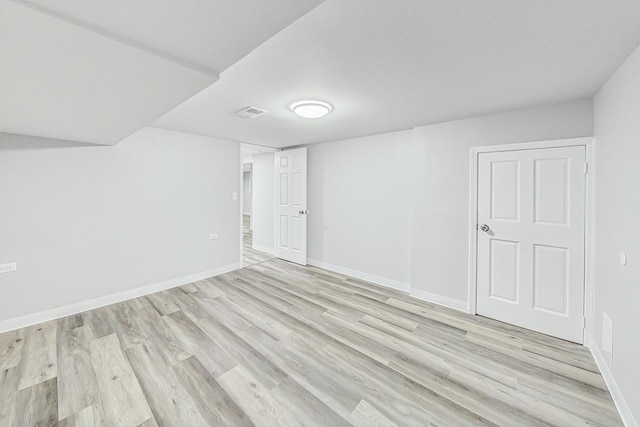 basement with light hardwood / wood-style flooring