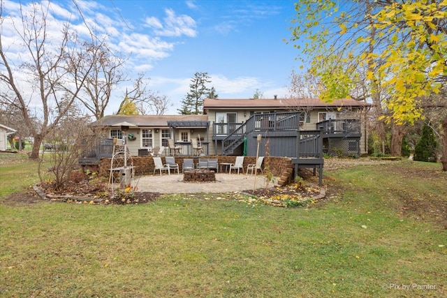 back of property featuring a patio area, a yard, a wooden deck, and a fire pit