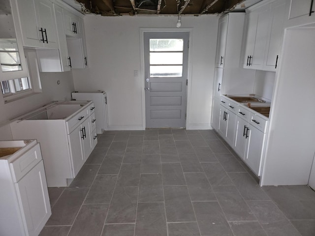 kitchen featuring tile patterned flooring and white cabinetry