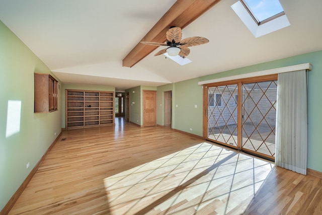 spare room featuring ceiling fan, lofted ceiling with skylight, and light wood-type flooring