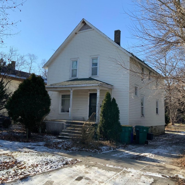 snow covered property featuring covered porch