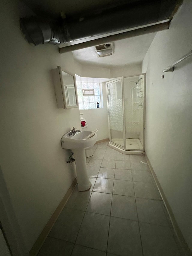 bathroom featuring tile patterned flooring, an enclosed shower, and toilet