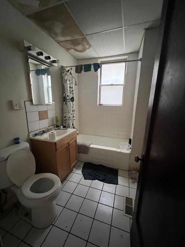 full bathroom featuring tile patterned floors, toilet, decorative backsplash, shower / tub combo with curtain, and vanity