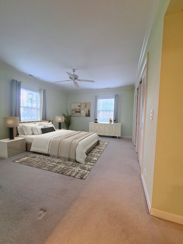 bedroom with carpet flooring, ceiling fan, crown molding, and multiple windows