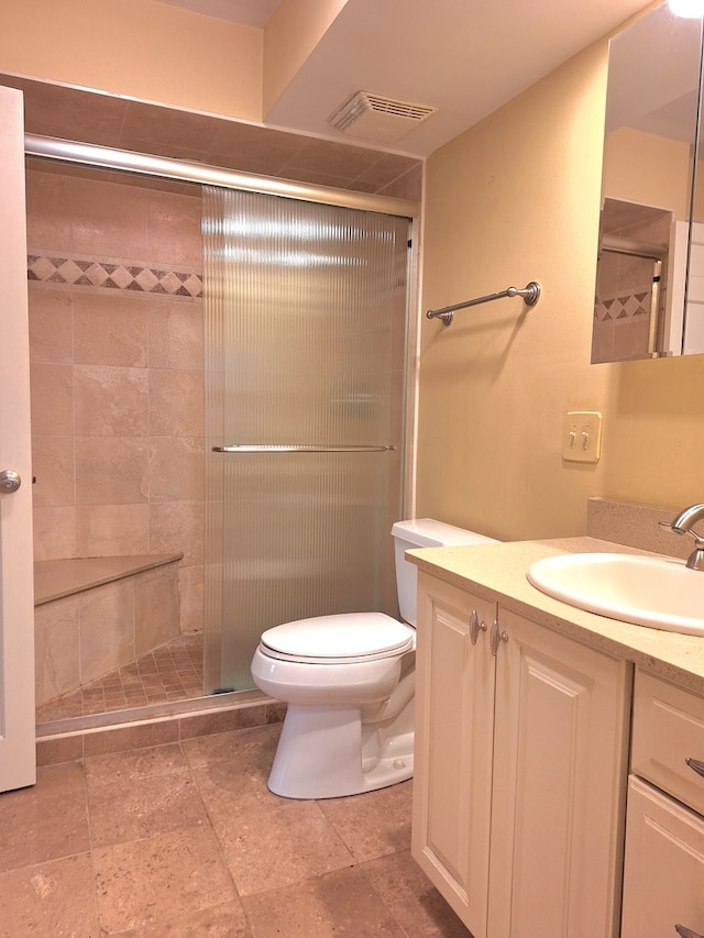 bathroom with vanity, toilet, and a shower with shower door