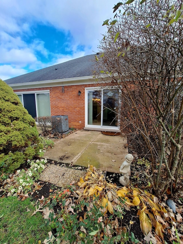 rear view of property featuring central AC unit and a patio area