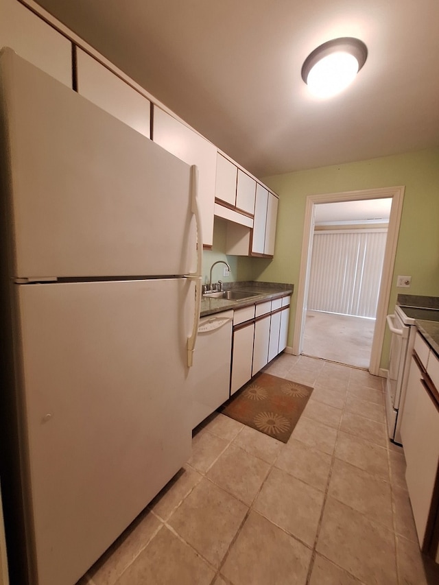 kitchen with sink, white cabinets, white appliances, and light tile patterned floors