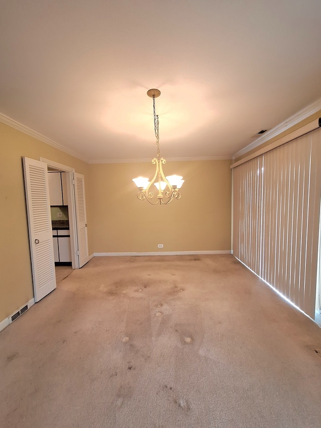 carpeted spare room with a notable chandelier and ornamental molding