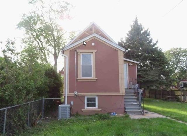 view of home's exterior with a yard and central air condition unit