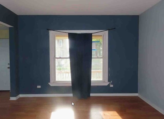 spare room featuring a wealth of natural light and hardwood / wood-style flooring