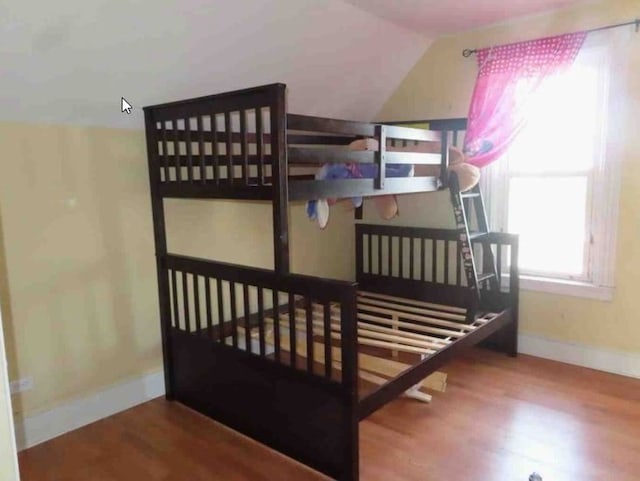 bedroom with lofted ceiling and hardwood / wood-style flooring