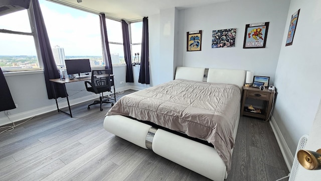 bedroom with baseboards and wood finished floors