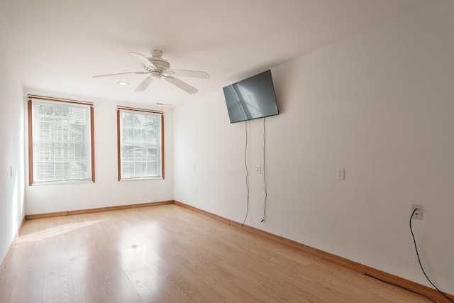 kitchen featuring wood walls, a center island, white refrigerator with ice dispenser, ceiling fan, and light wood-type flooring