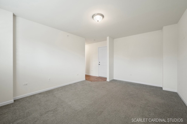 unfurnished room featuring dark carpet