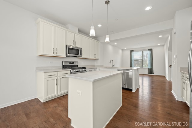 kitchen featuring a kitchen island, kitchen peninsula, stainless steel appliances, and white cabinetry