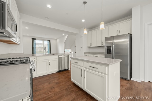 kitchen featuring sink, a kitchen island, dark wood-type flooring, and appliances with stainless steel finishes