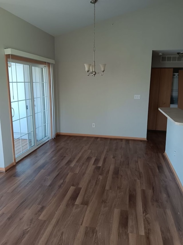 unfurnished dining area with a chandelier and dark hardwood / wood-style floors