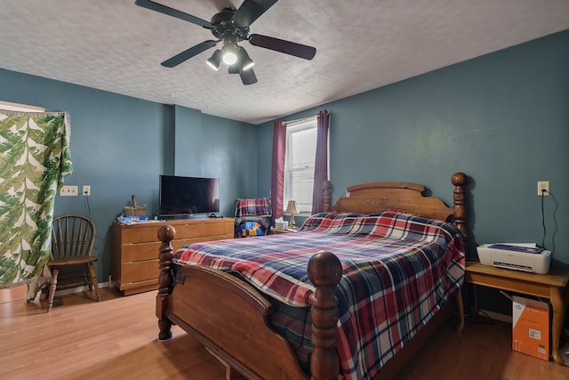 bedroom with hardwood / wood-style flooring, ceiling fan, and a textured ceiling