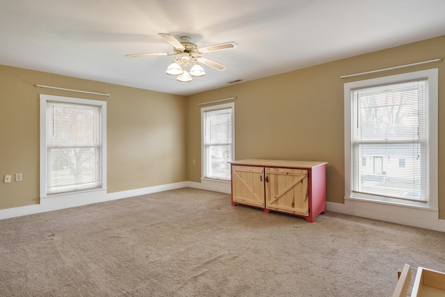 empty room with ceiling fan and light colored carpet