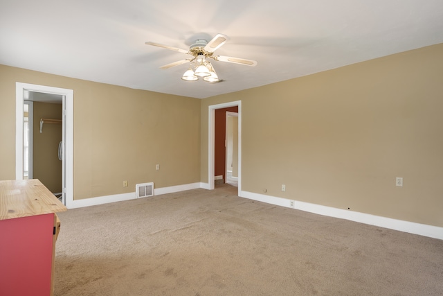 spare room with ceiling fan and light colored carpet