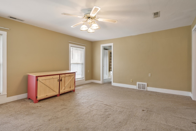 spare room featuring ceiling fan and light carpet