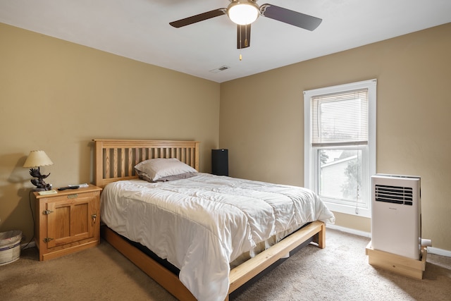 carpeted bedroom featuring heating unit and ceiling fan