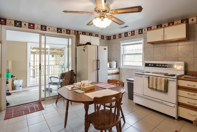 kitchen with white appliances, tile walls, and light tile patterned floors