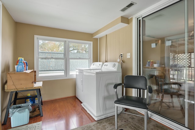 clothes washing area featuring hardwood / wood-style flooring and independent washer and dryer