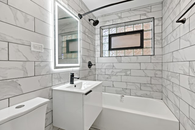 full bathroom featuring vanity, toilet, tile walls, and tiled shower / bath combo