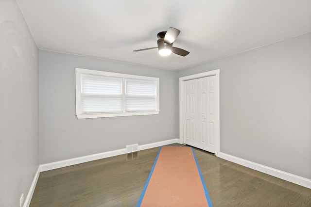 unfurnished bedroom with a closet, ceiling fan, and dark hardwood / wood-style flooring